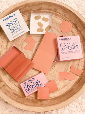 different types of paper facial patches spread out in a wooden dish