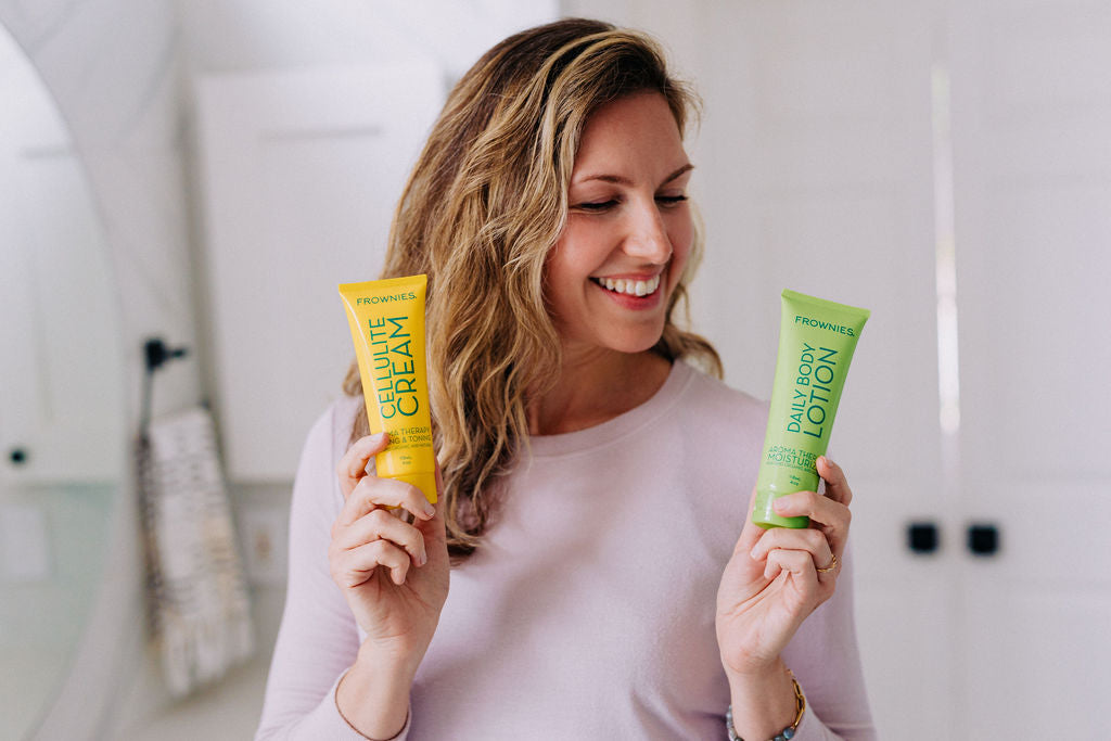 woman holding up two products that contain essential oils