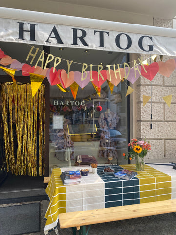 Herzlich Willkommen zum HARTOG-Laden-Geburtstag. Für den Glamour-Faktor mit goldenem Glitzer-Vorhang an der Türe.