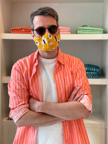 Unser Chef vom Team HARTOG Berlin im Knesekiez in Charlottenburg im Design-Klassiker Hemd Jokapoika von Marimekko in sommerlichem orange-rosa.