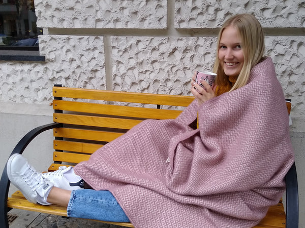 Lumi auf der HARTOG-Bank in einer rosanen Klippan-Decke eingehüllt mit Tee aus einem Taika-Becher von iittala.. gibt es ein nordischeres Setting in ganz Berlin?