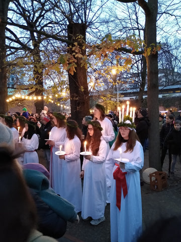 Lucia mit der Lichterkrone und einem weißen Kleid