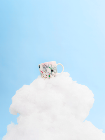 Die Moomin Winter Tasse 2023 Sliding schwebt hier auf einer rosa Watte-Wolke. Passend zum Design denn auch hier sind die Wolken rosa.