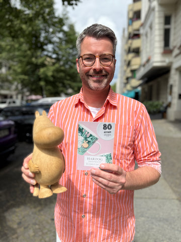 Torben mit unserem Holz-Mumin und der Einladung zum Mumin's Day 2025.