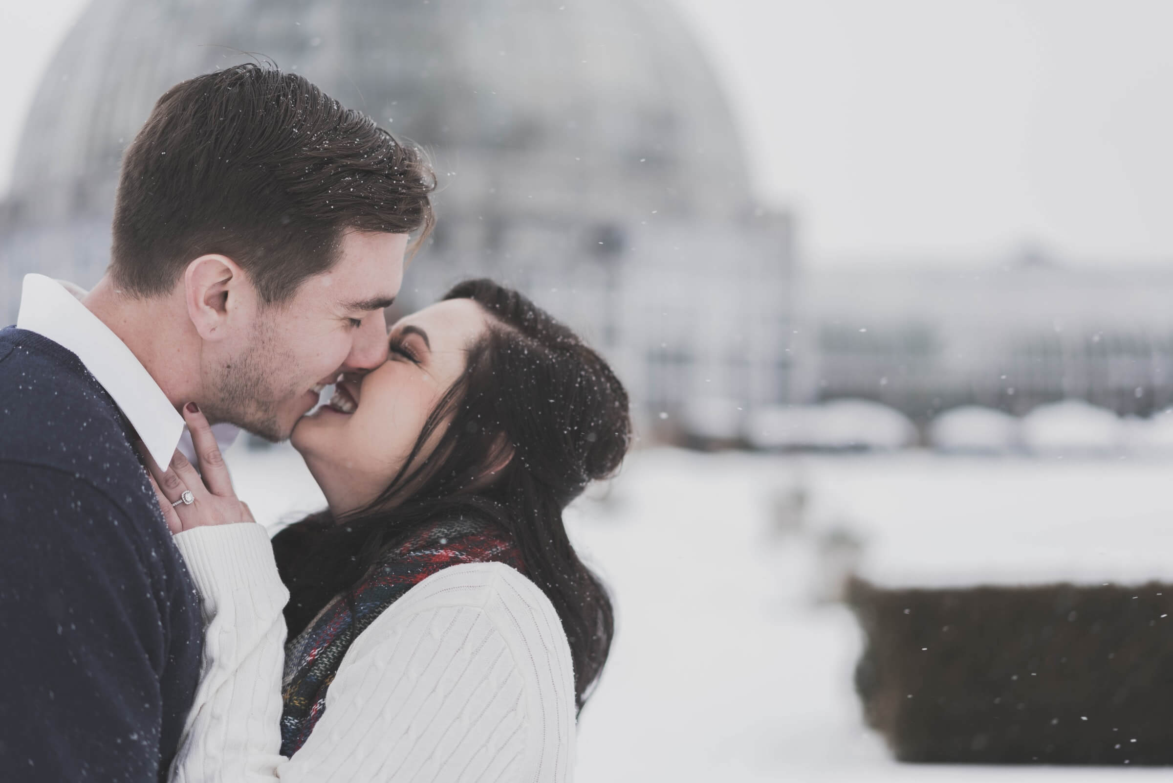 a man and woman kissing in the snow