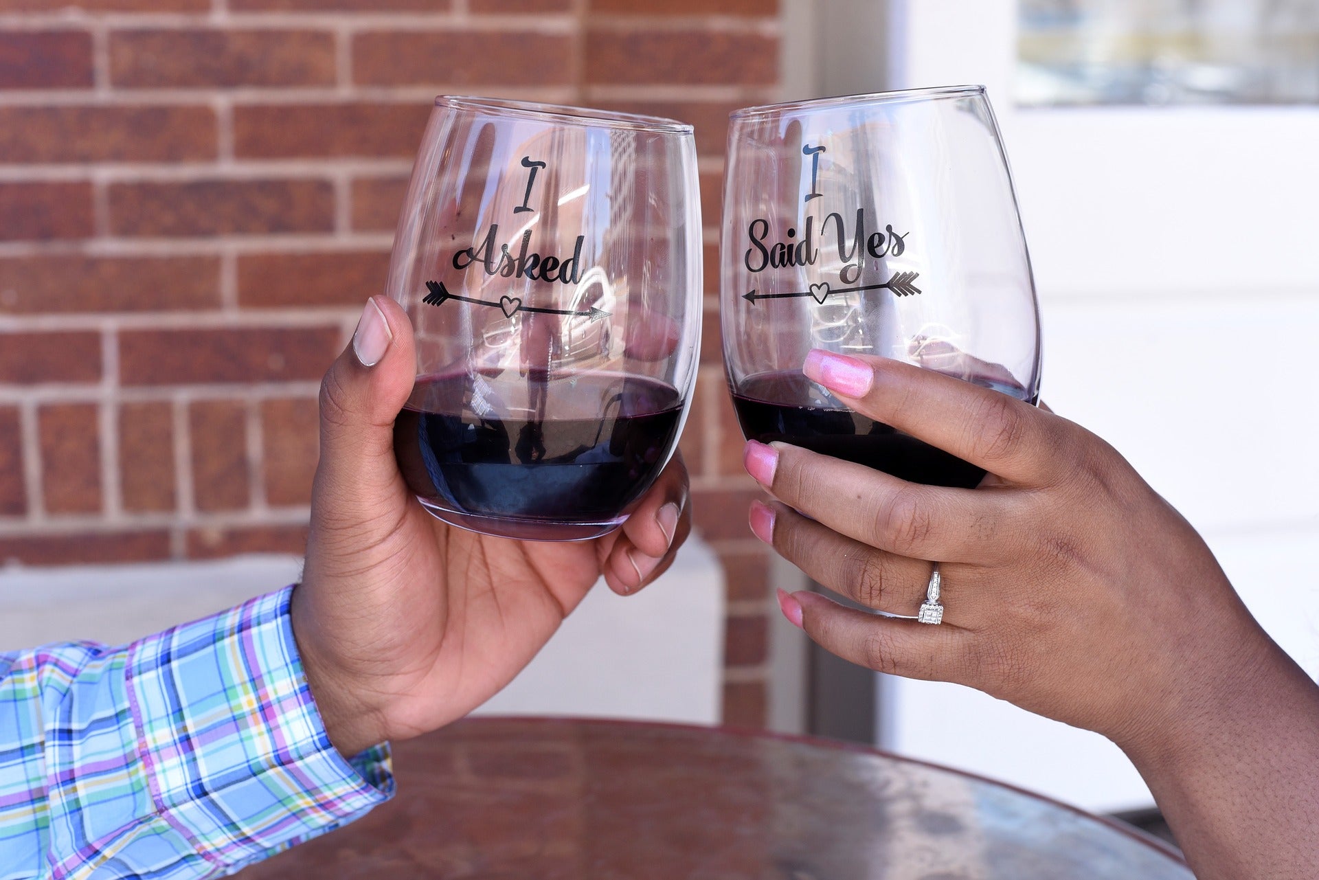 newly engaged couple cheering wine glasses