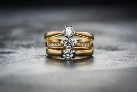  A stack of three yellow-gold diamond rings.
