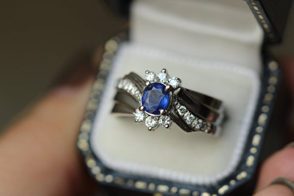 A twisted silver sapphire ring in a ring box