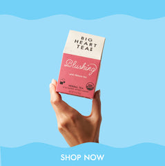 Hand holding blushing tea, on blue background. CTA shop now