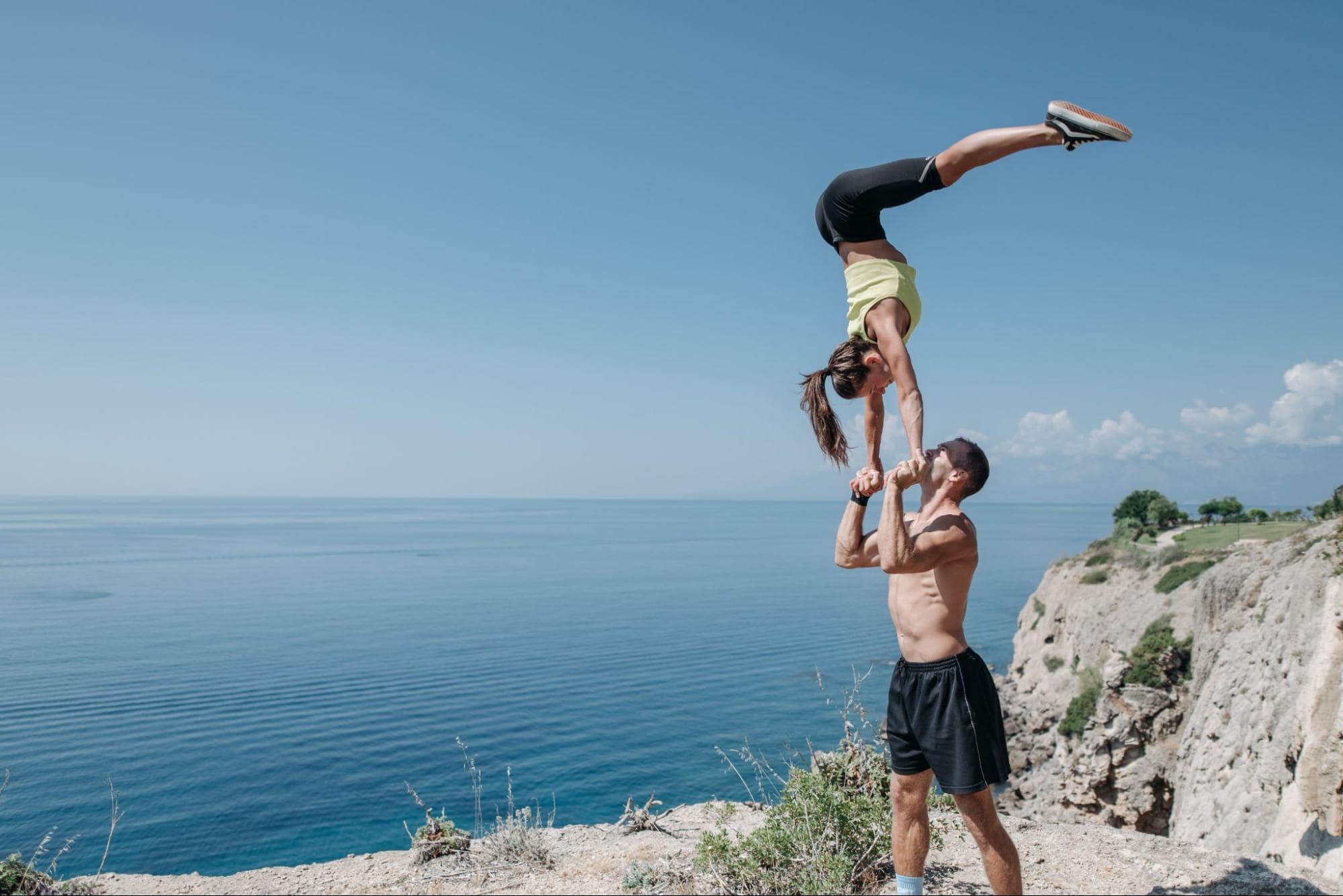 couple performing athletic trick outside