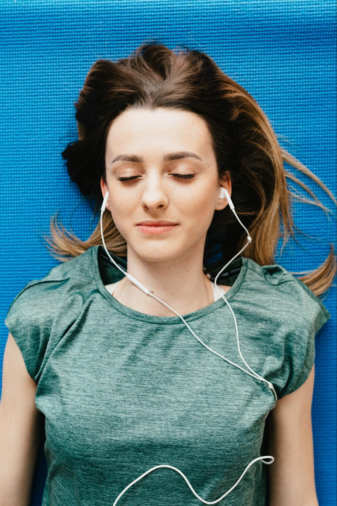 Person meditating with earbuds in