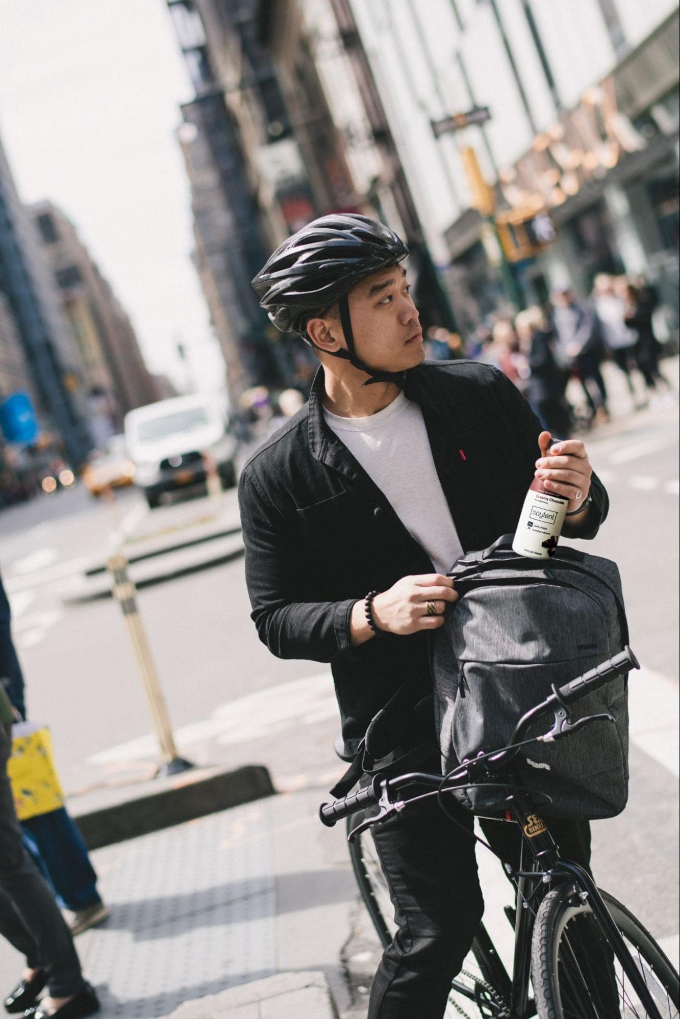 Image of a person on a bike holding a bottle of Soylent