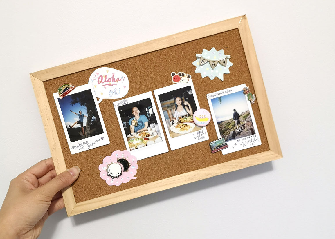 Decorated corkboard with enamel pins and stickers