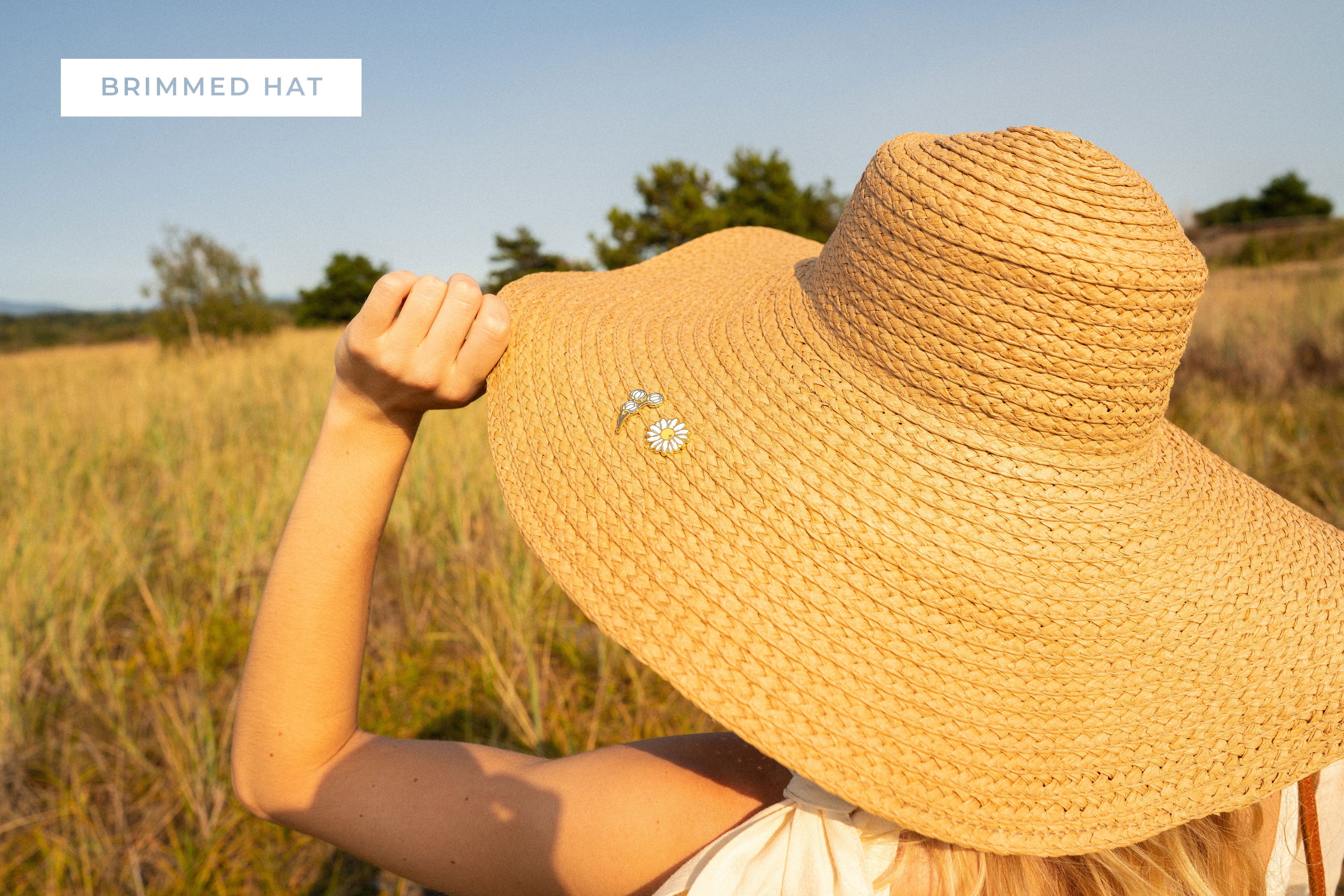 wide brimmed sunhat with daisy flower pins