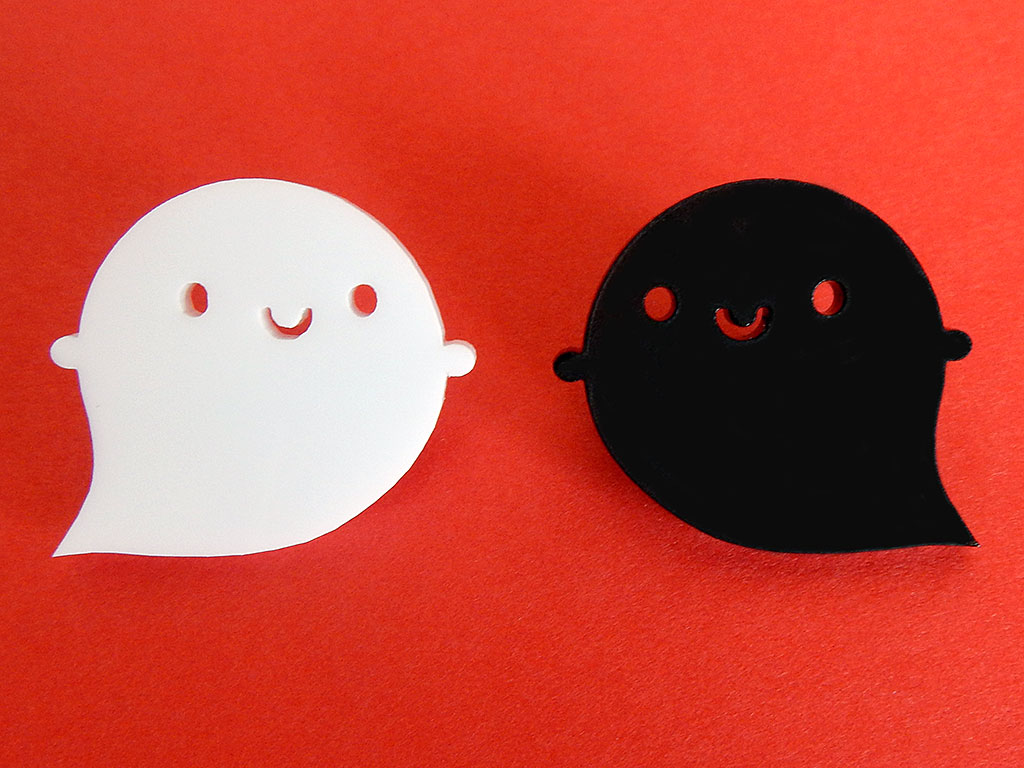 2 happy kawaii ghost brooches made from acrylic. The original white faces right and the evil black faces left