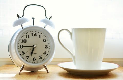 alarm clock by tea cup