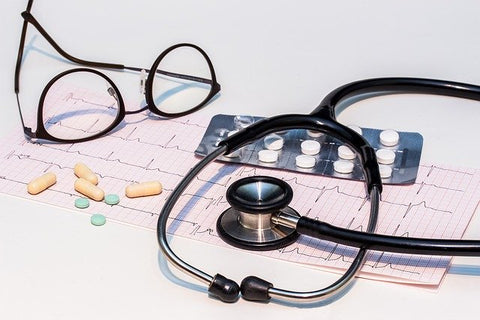 pills and doctor's stethoscope and glasses