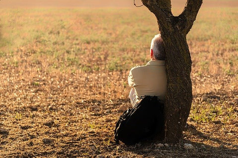 man sitting up against a tree - taking a break