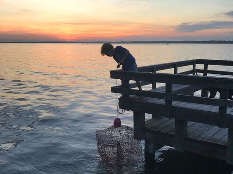 Youth checking a crab pot on a pier