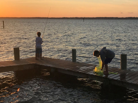 Boys with fishing rod and cast net on pier