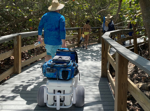 Fisherman hauling gear with the Calcutta Outdoors beach cart