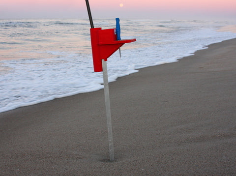 Surf fishing sand spike with bait knife on beach