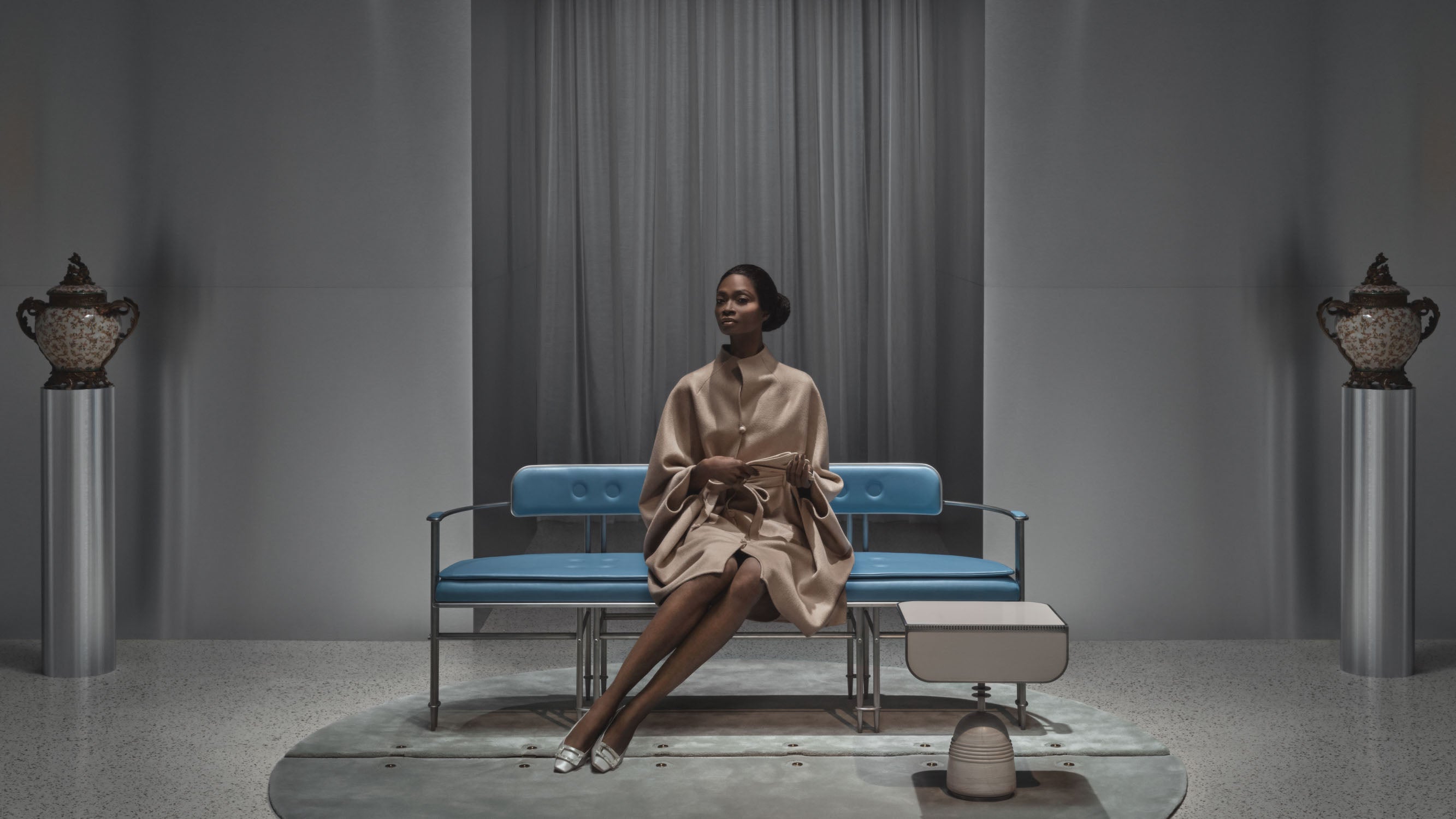 A woman sits on an EPISODE settee, which is positioned on a circular modular rug. 