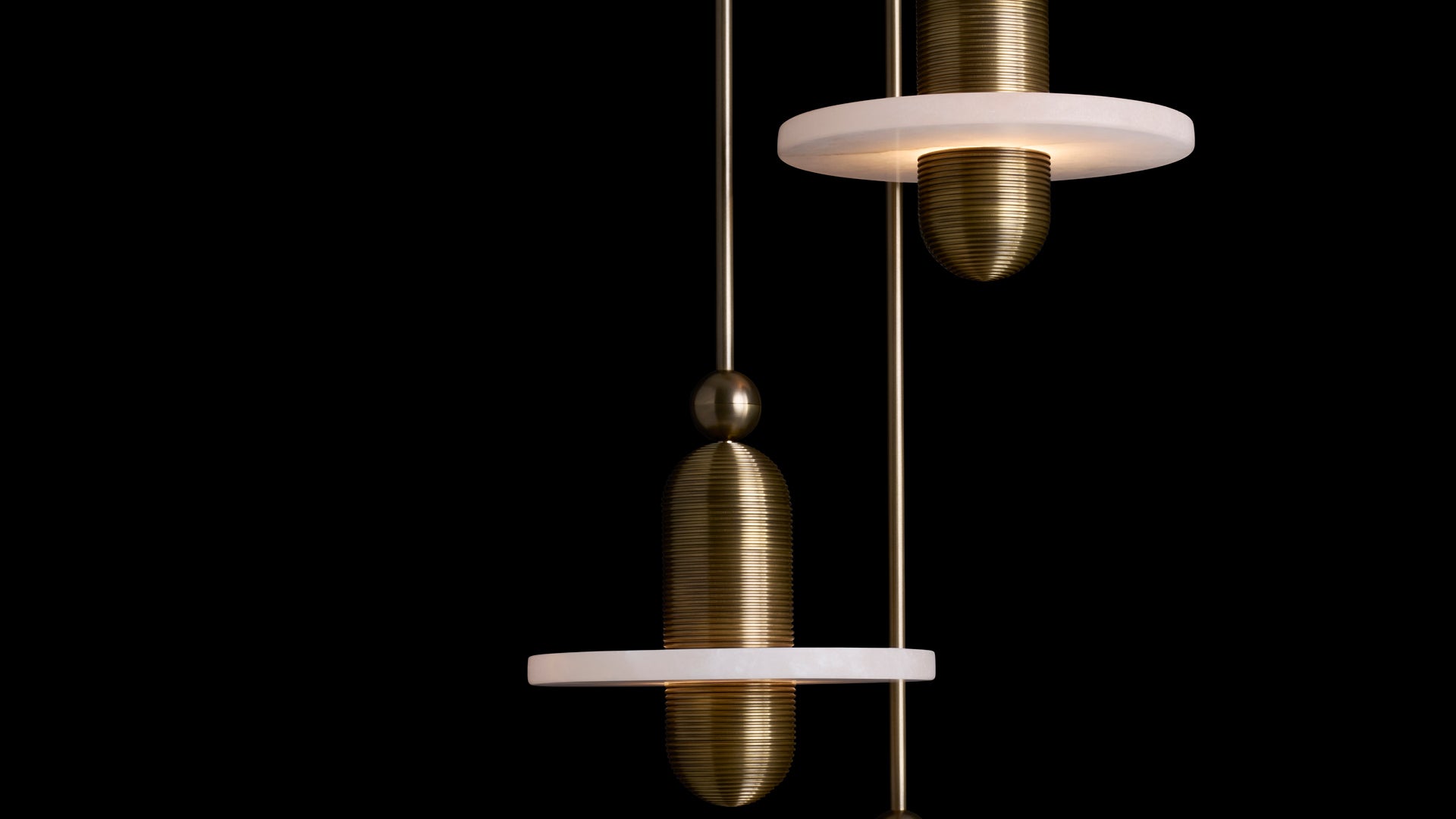 Close up of the Median 3 Installation in Aged Brass against a black background. 