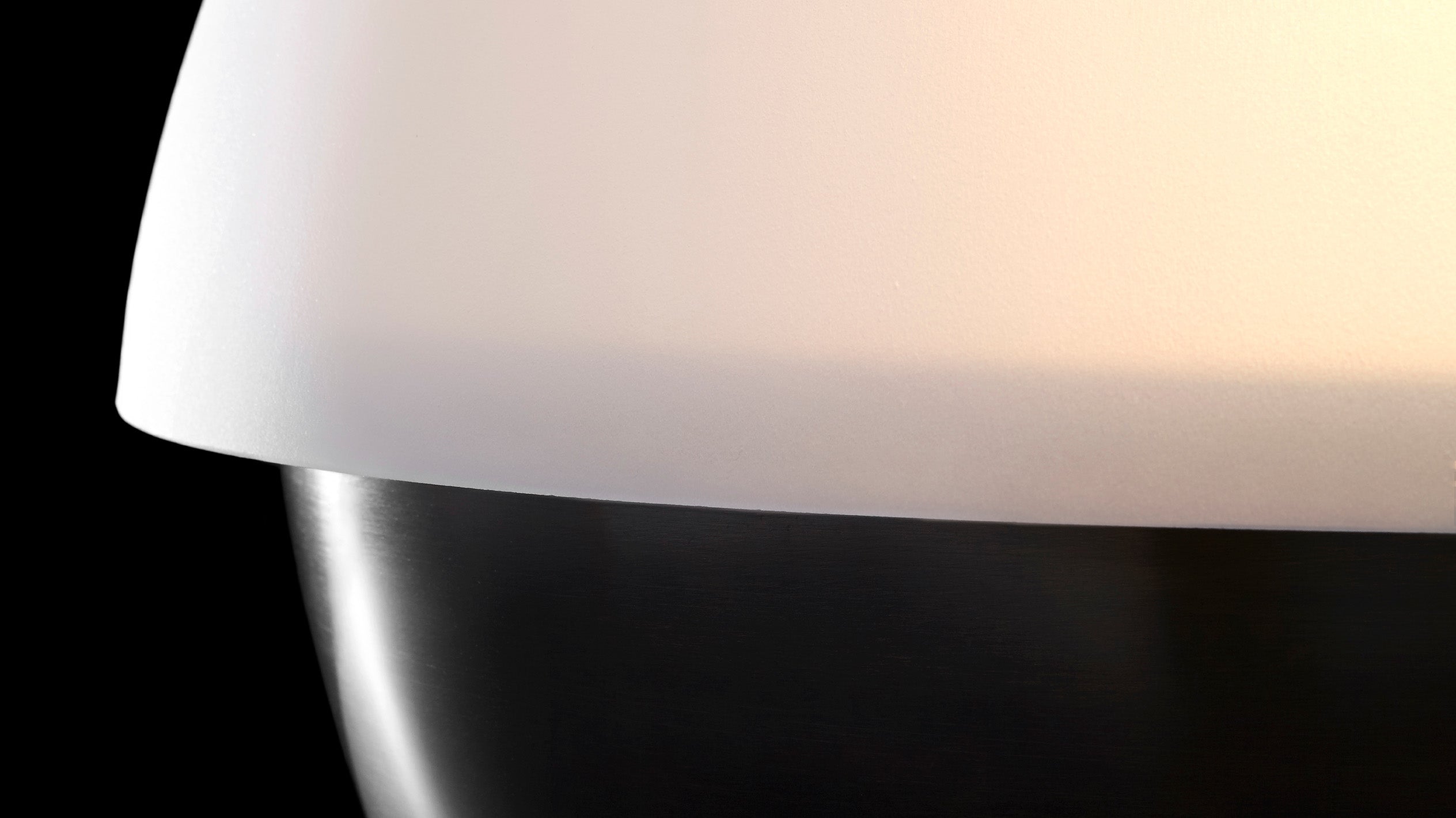 Close up of an illuminated AXON table lamp showing details of the Tarnished Silver finish. 