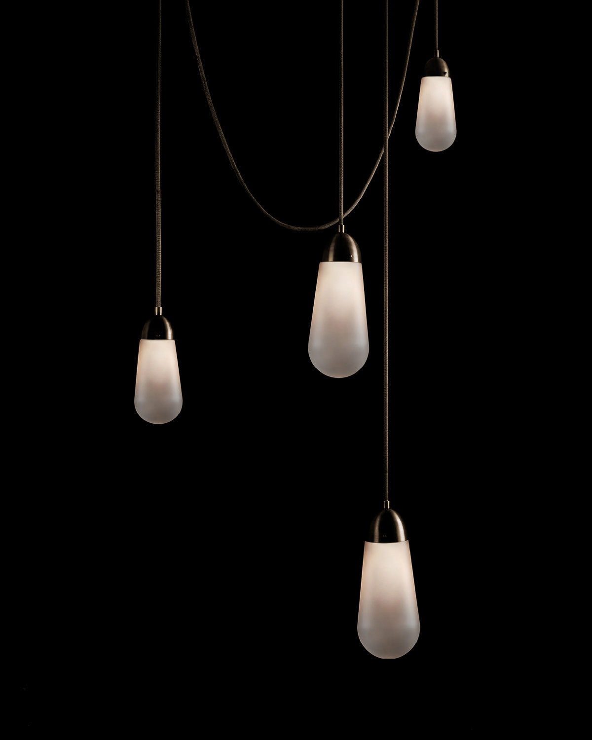 A LARIAT installation, comprised of four ceiling pendants in an assortment of sizes and heights, in Oil-Rubbed Bronze finish. 