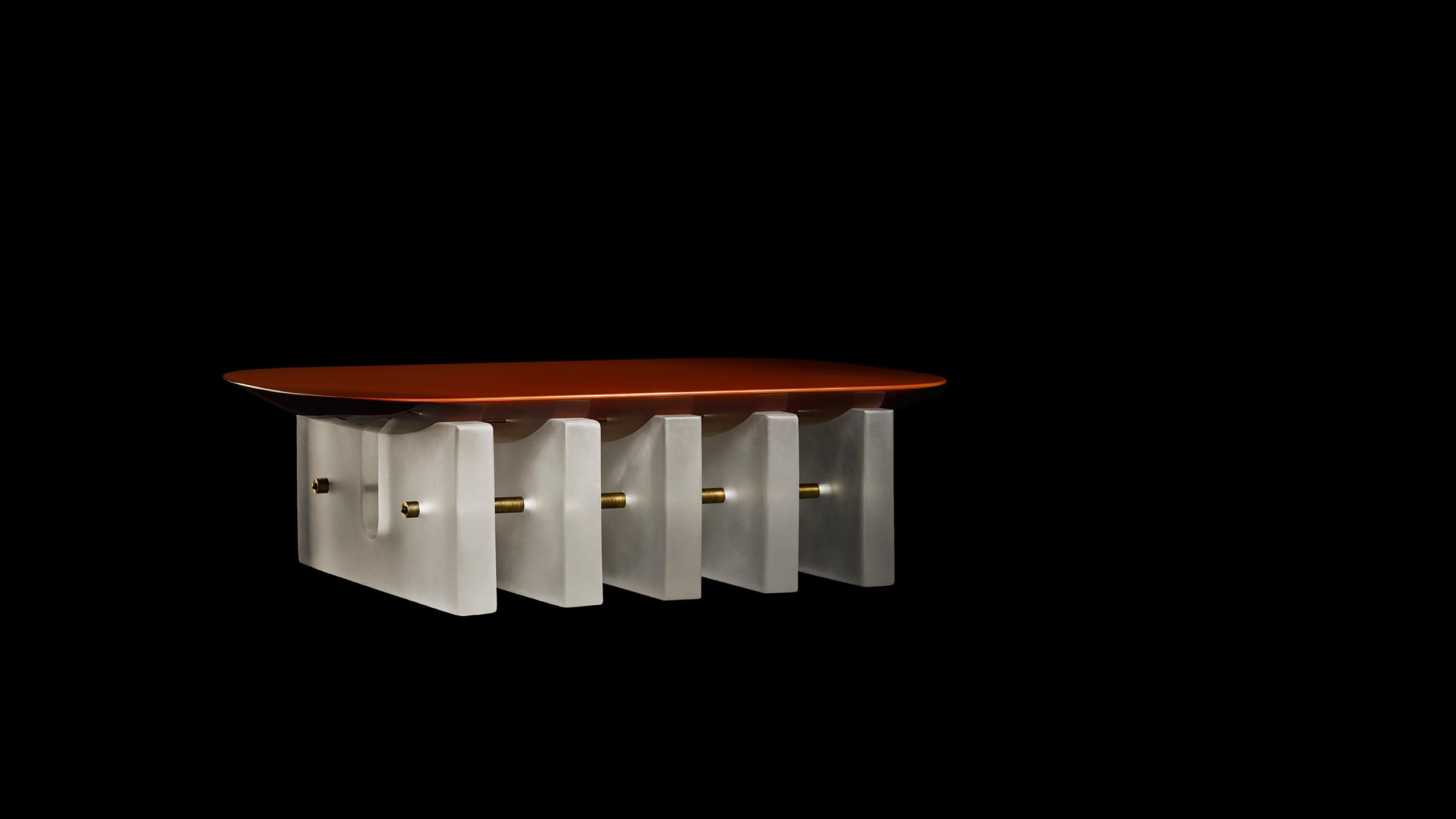 SEGMENT coffee table in Cinnabar Lacquer against a black background.