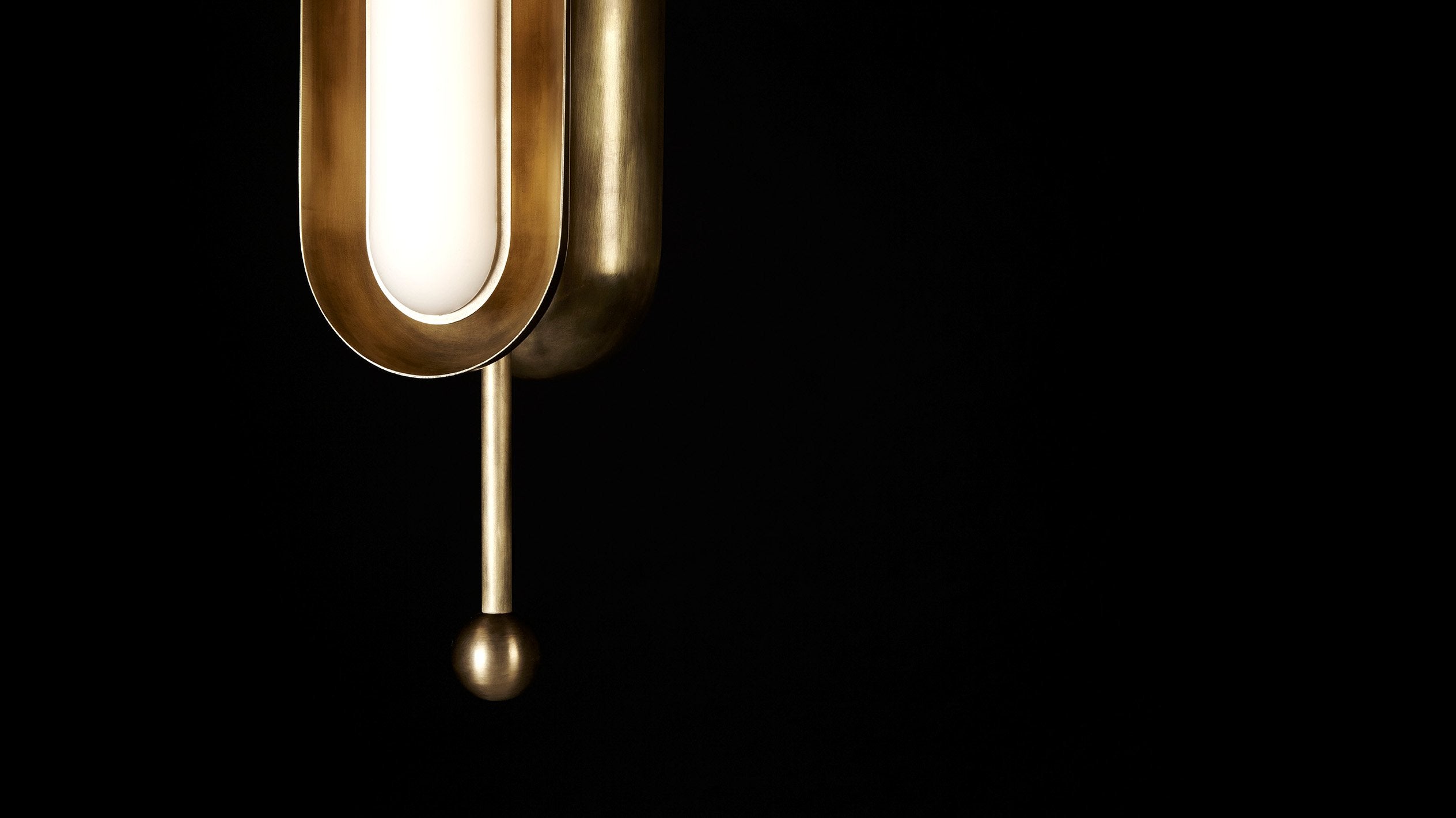 Close up of an illuminated CIRCUIT : 2 vertical ceiling pendant showing details of the Aged Brass finish.