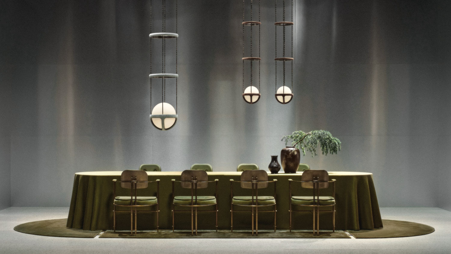 A trio of REPRISE ceiling pendants hanging over a dining table that is on a SEQUENCE modular rug. 