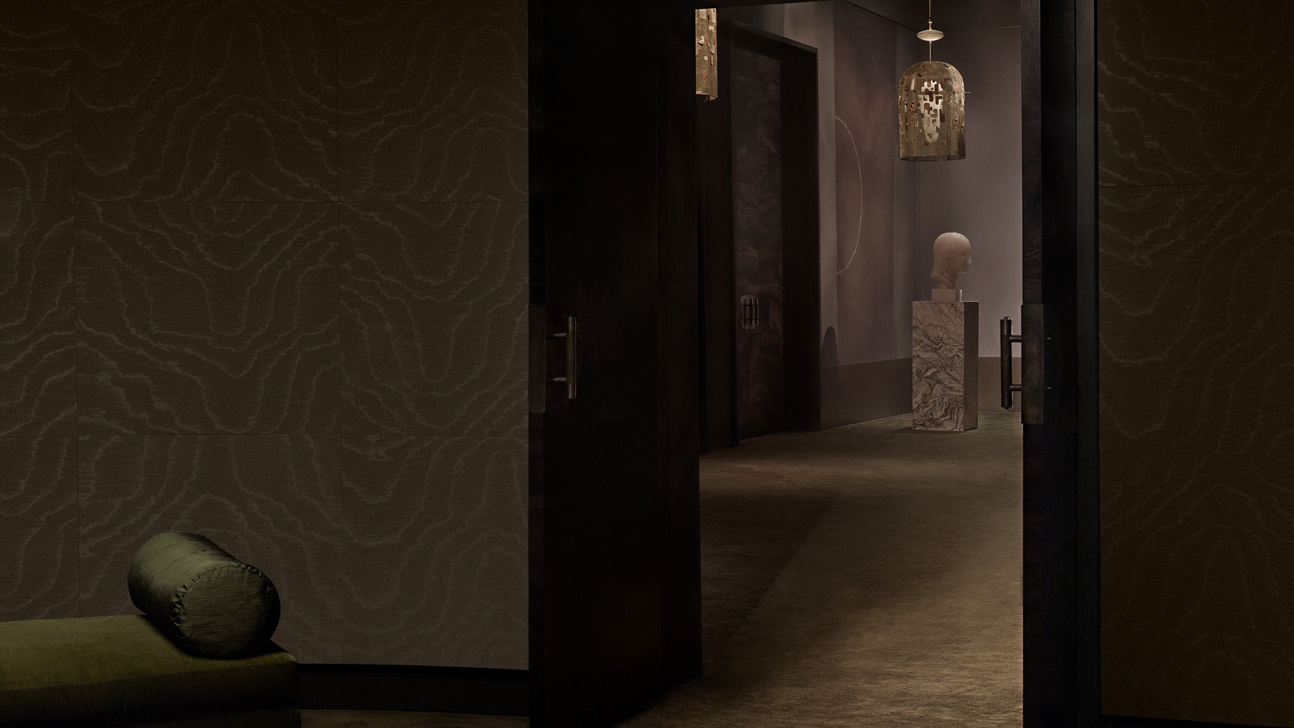 View of a room through a doorway that is decorated with two INTERLUDE hand embroidered ceiling pendants. 