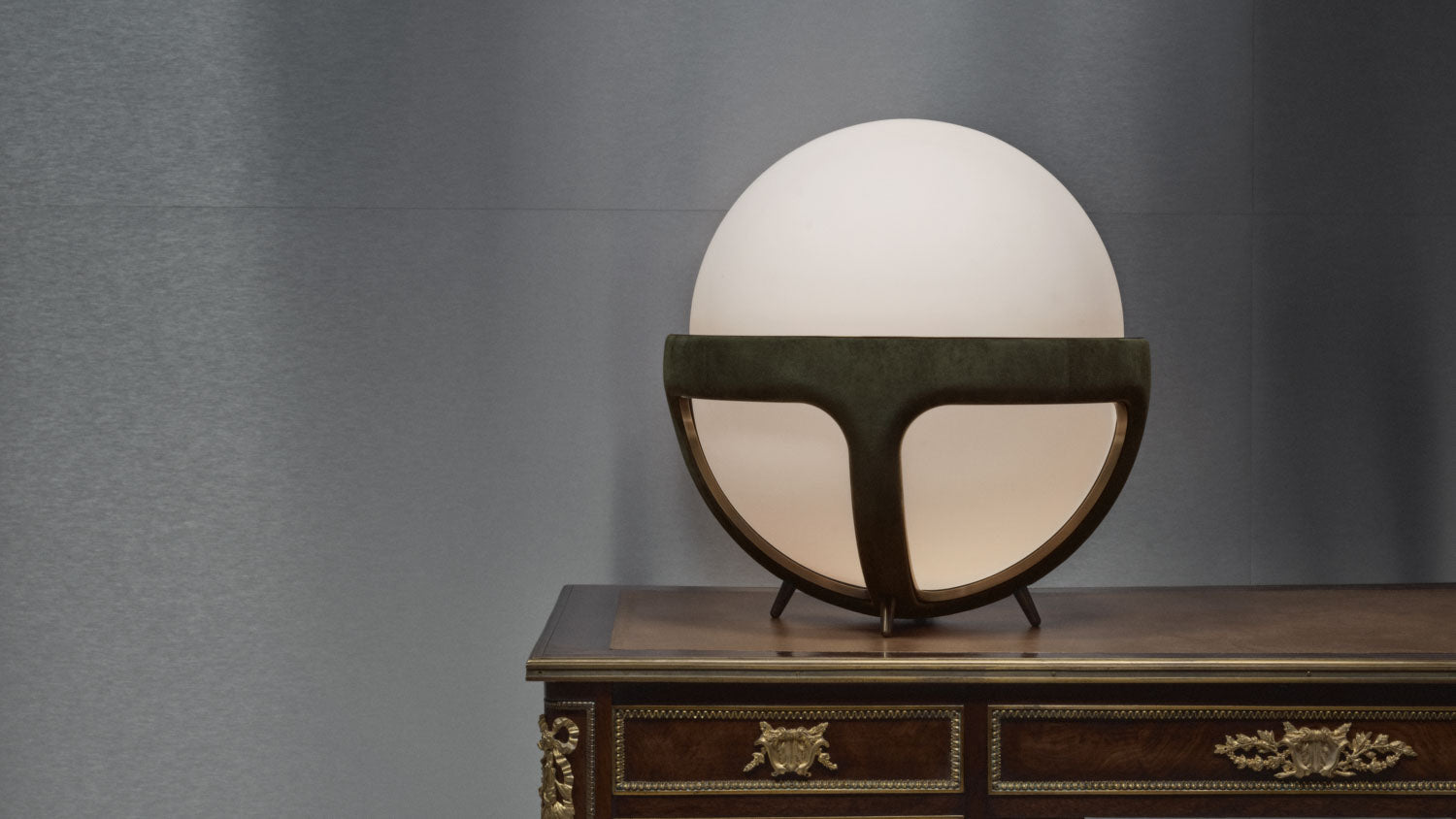 REPRISE table lamp in Juniper Suede and Aged Brass positioned on a vintage desk.