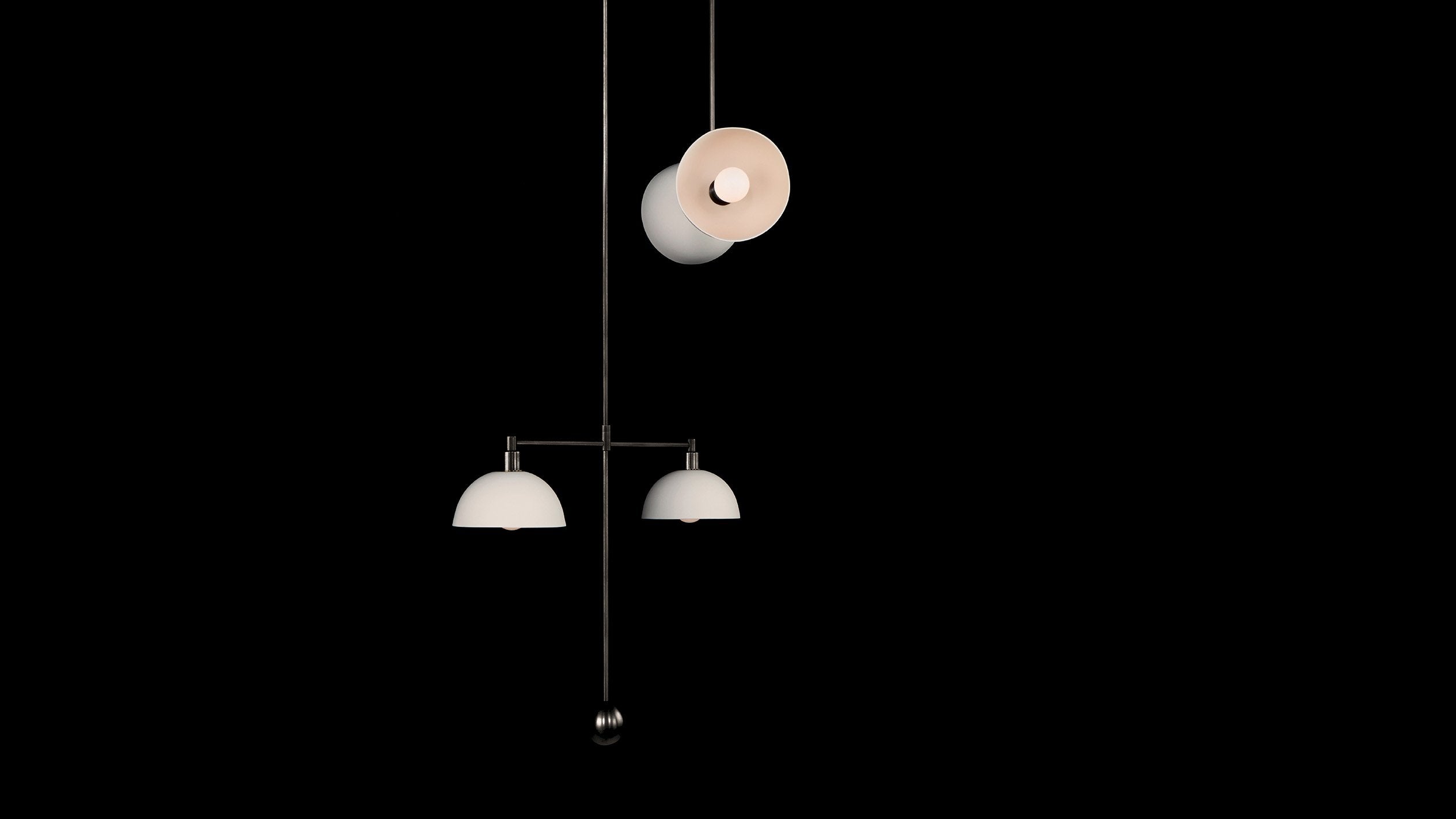 TRAPEZE : 4 MOBILE ceiling pendant in Blackened Brass finish with Porcelain bowls, hanging against a black wall. 