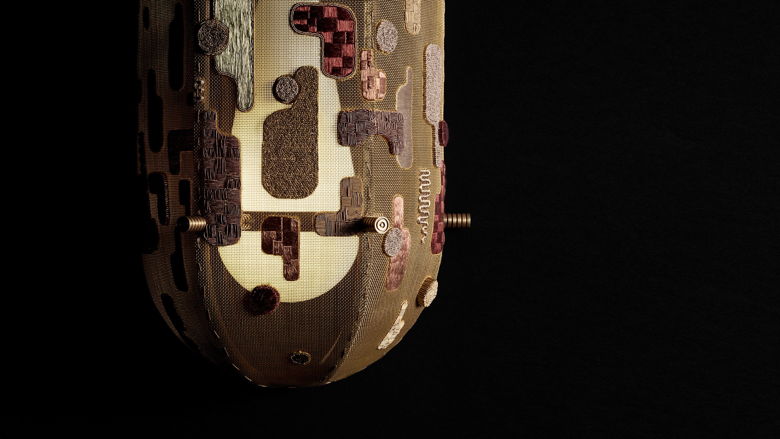 Close up of an INTERLUDE wall sconce showing details of the hand-embroidered shade.