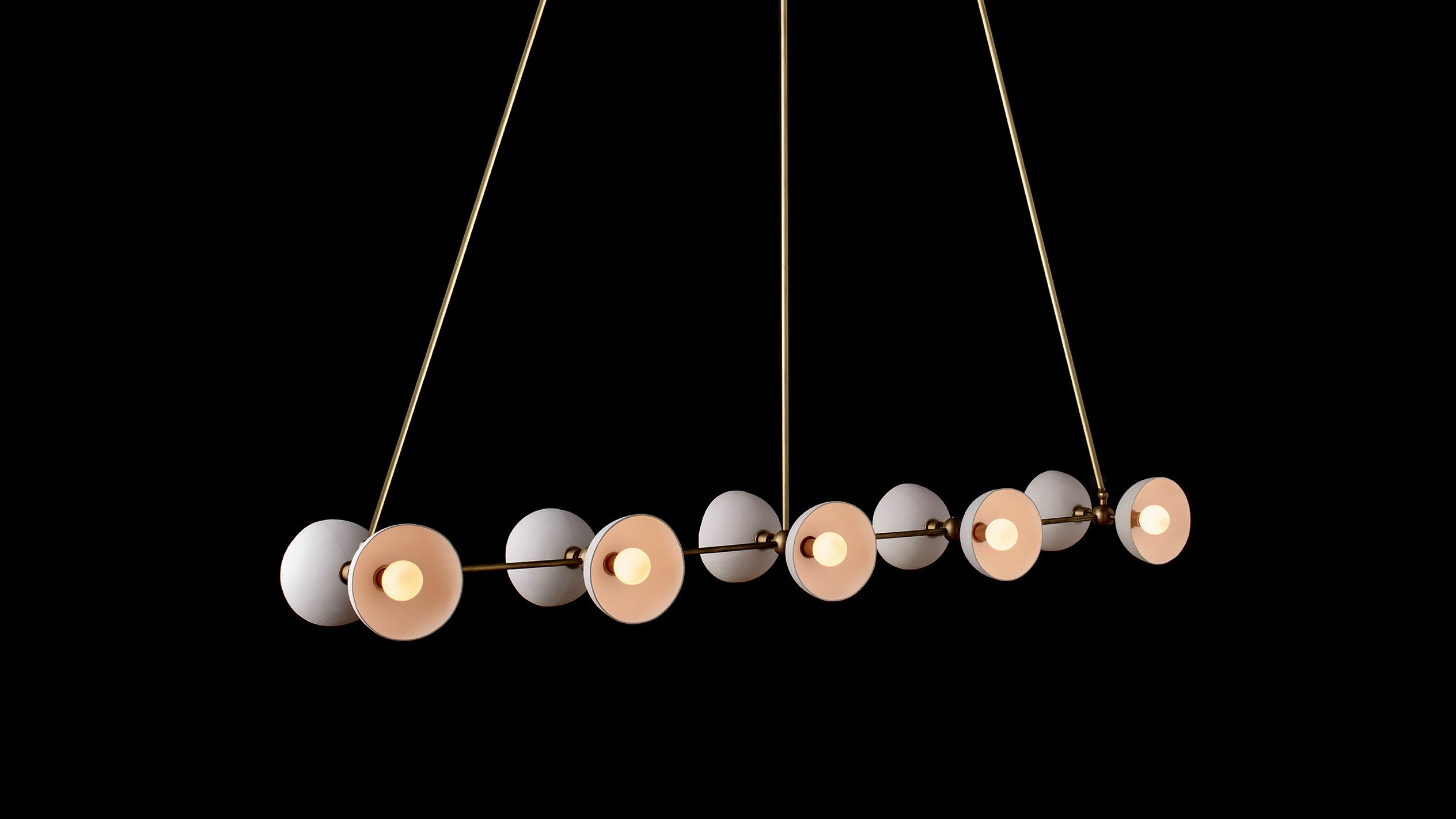 TRAPEZE : 10 ceiling pendant in Aged Brass finish with Porcelain bowls, hanging against a black background. 