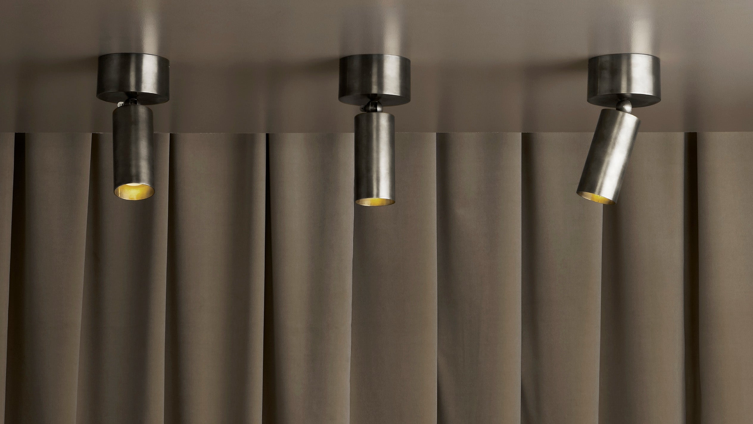 A trio of ceiling mounted CYLINDER spotlights in Tarnished Silver finish.