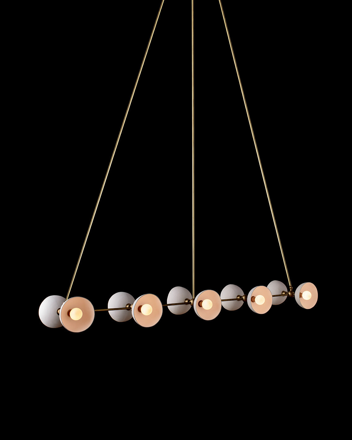 TRAPEZE : 10 ceiling pendant in Aged Brass finish with Porcelain bowls, hanging against a black background. 