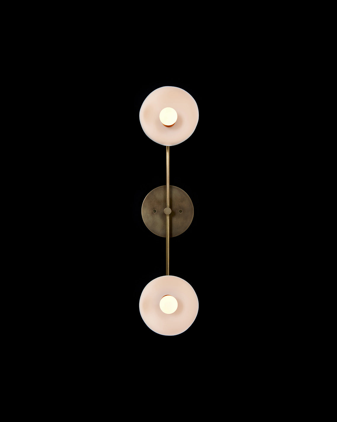 TRAPEZE : 2 surface light in Aged Brass finish with Porcelain bowls, mounted vertically to a black wall. 
