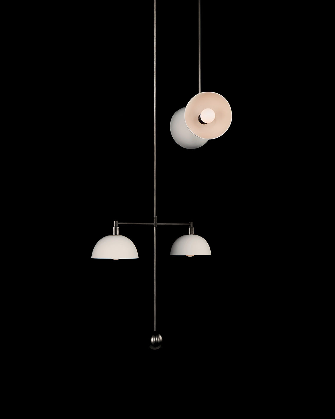 TRAPEZE : 4 MOBILE ceiling pendant in Blackened Brass finish with Porcelain bowls, hanging against a black wall. 