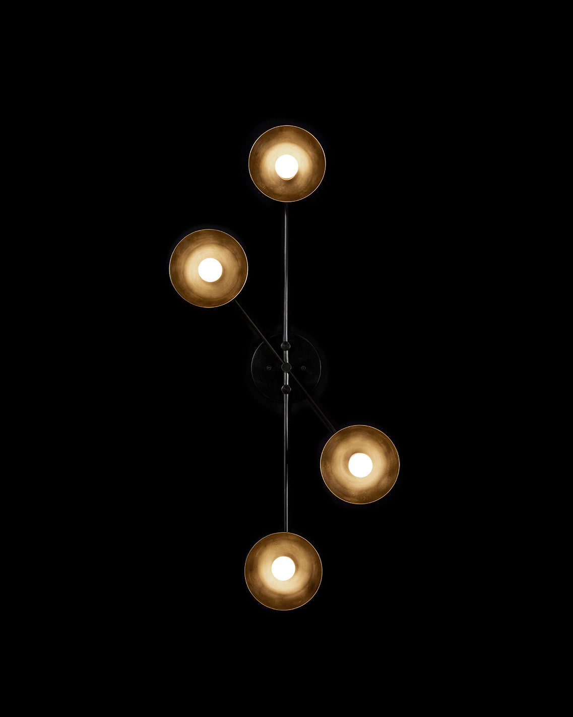 A TRAPEZE : 4 surface light mounted to a black wall.