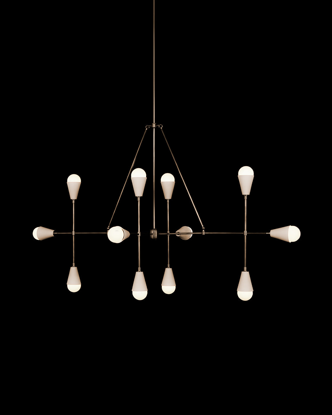 TRIAD : 12 LINEAR ceiling pendant in Aged Brass finish with Porcelain, hanging against a black background. 