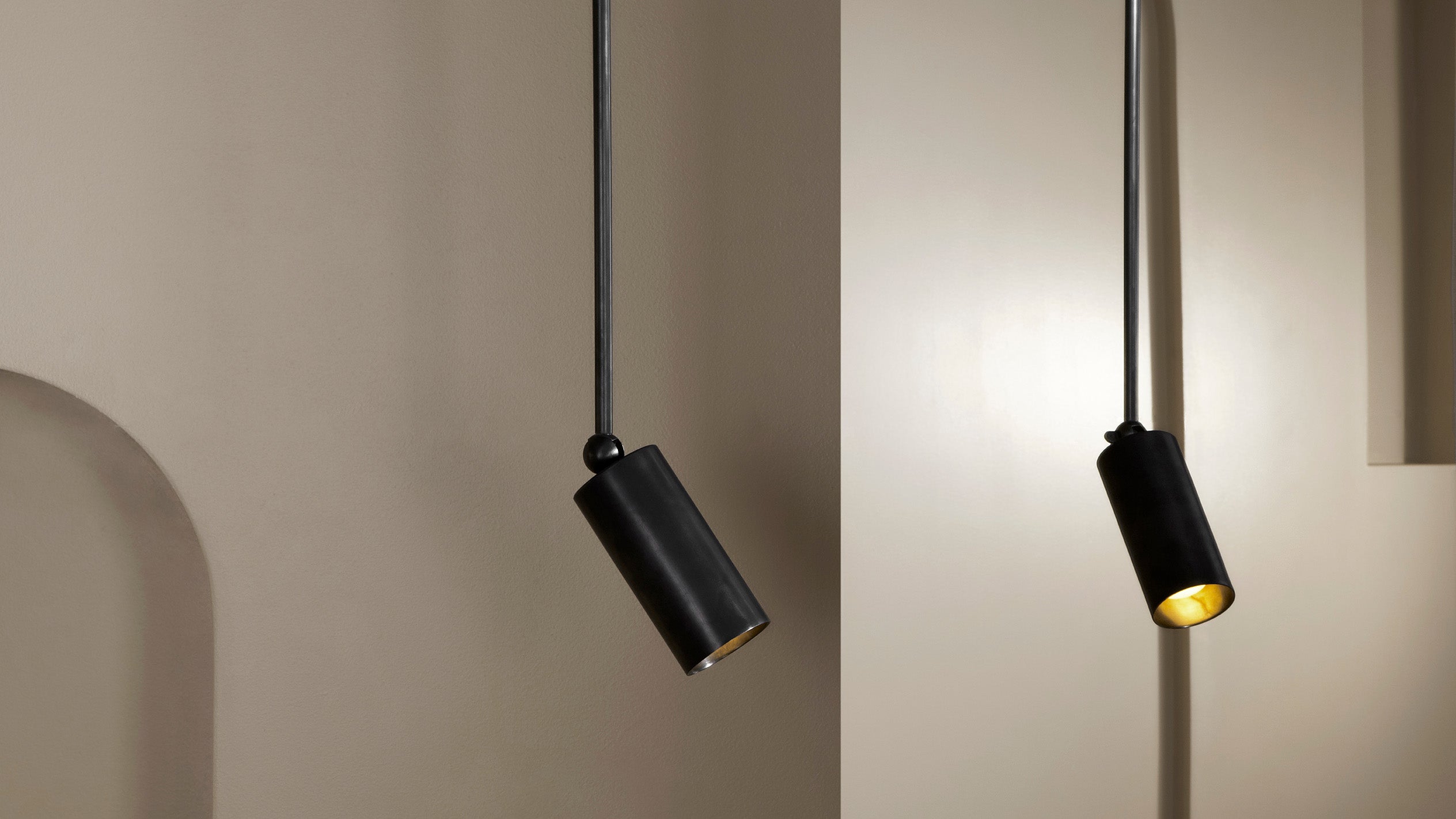 A pair of CYLINDER : DOWNLIGHT EXTENDED ceiling pendants in Blackened Brass finish. 