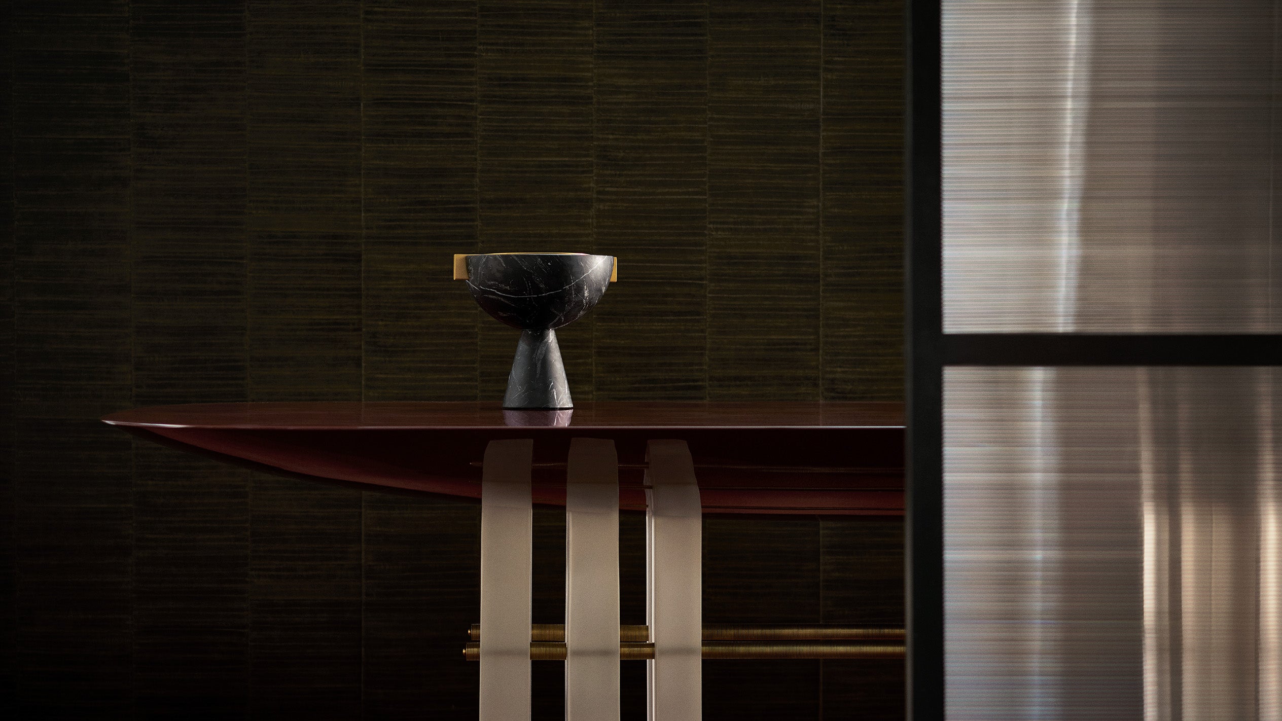 SEGMENT dining table in Oxblood Lacquer decorated with an object used for burning incense.