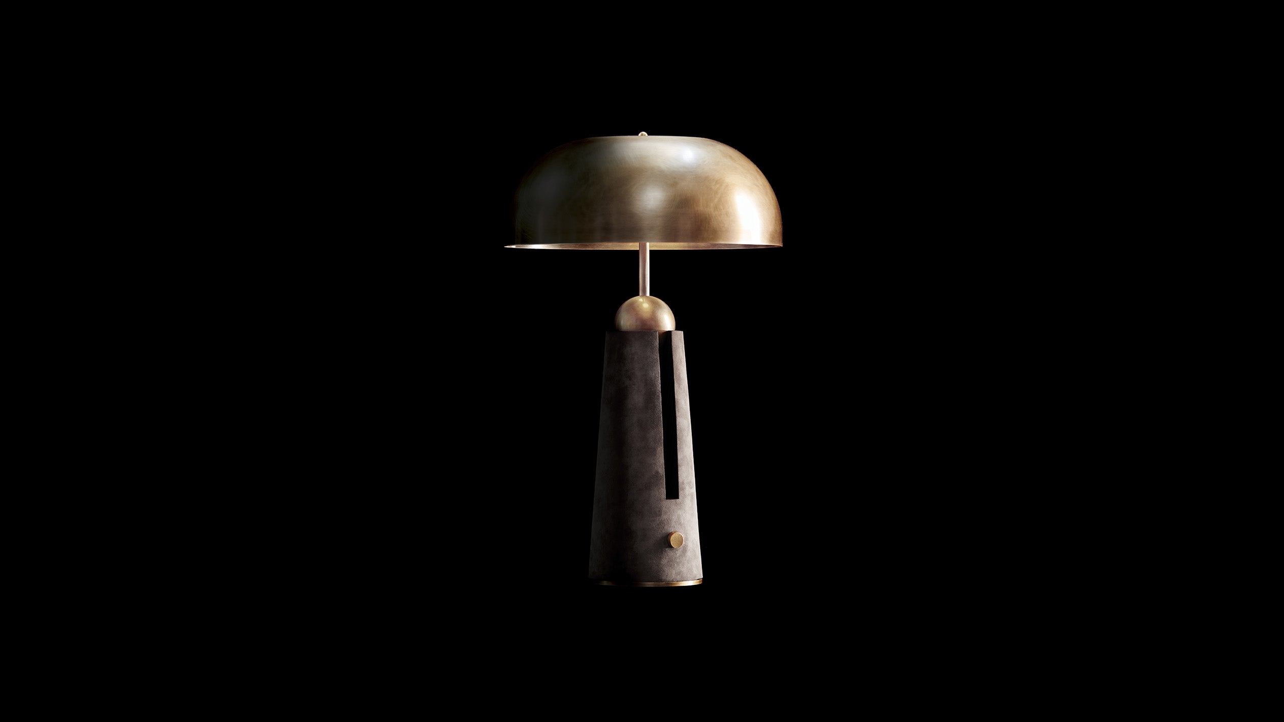 METRONOME table lamp in Aged Brass finish with Pewter Suede against a black background. 