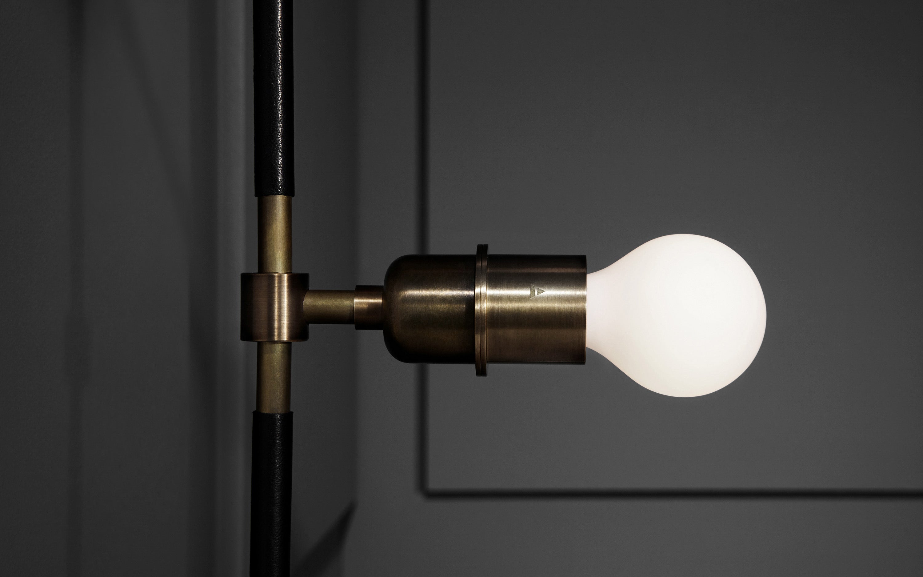 Close up of the VANITY : SCONCE showing details of the bulb and metal finish. 