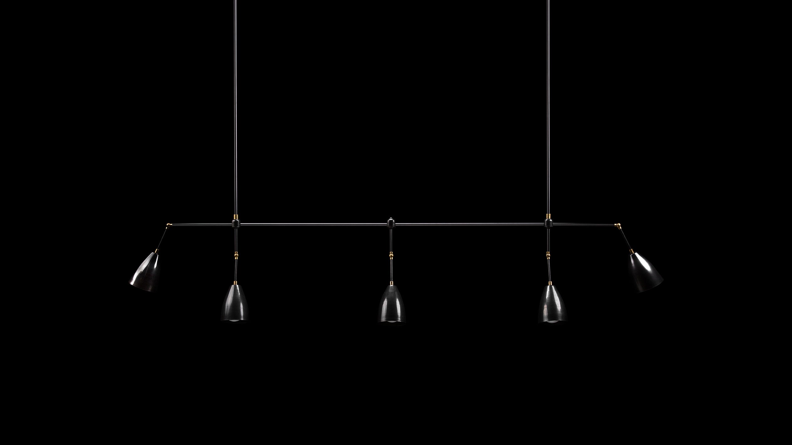 TWIG : 5 LINEAR ceiling pendant in Blackened Brass and Aged Brass finish, hanging against a black background. 