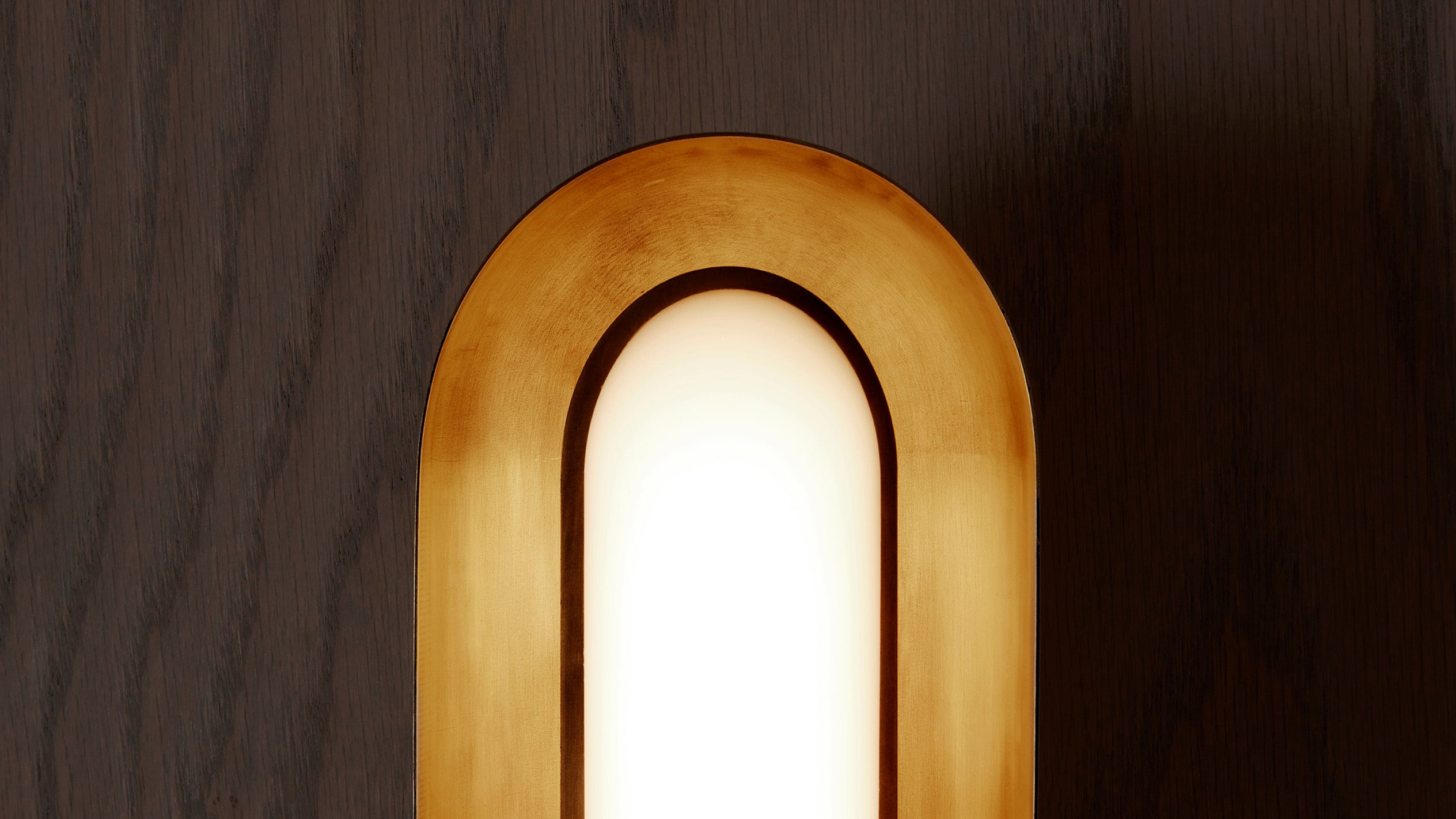 Close up of an illuminated CIRCUIT surface light showing the details of the Aged Brass finish. 